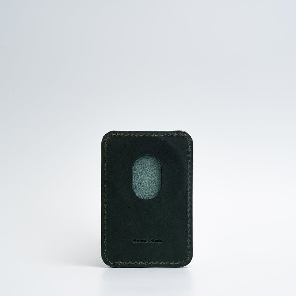 Green top-grain leather MagSafe wallet for iPhone on white background, highlighting smooth texture.