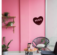 Pink Hugs Candy Heart metal wall art mounted on a pale pink wall