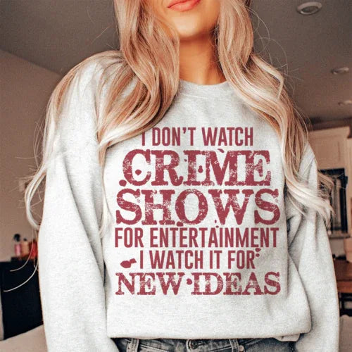 Close-up of peach sweatshirt text 'I Don't Watch Crime Shows For Entertainment' showing soft fleece fabric.