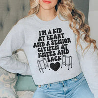 Sport grey sweatshirt with playful 'I'm A Kid At Heart And A Senior Sitizen' text design on front.