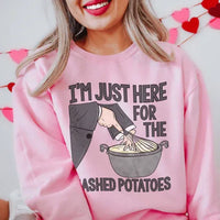 Peachy pink sweatshirt featuring 'I'm Just Here For The Mashed Potatoes' text printed in white and orange.