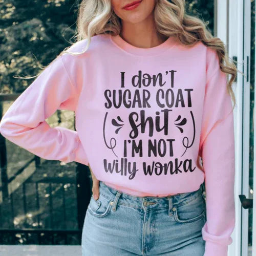 Light pink sweatshirt with white 'I'm Not Willy Wonka' lettering, shown flat on neutral surface.