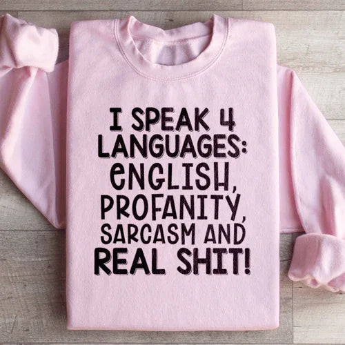 Detailed view of peach sweatshirt sleeve and cuff with I Speak Four Languages text visible.