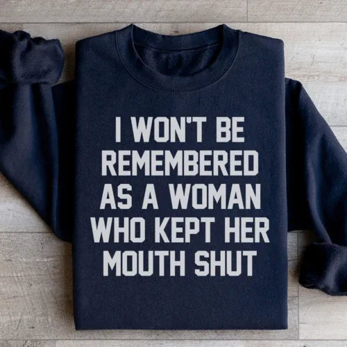 Black sweatshirt showing the phrase 'I Won't Be Remembered As A Woman Who Kept Her Mouth Shut' in white font.