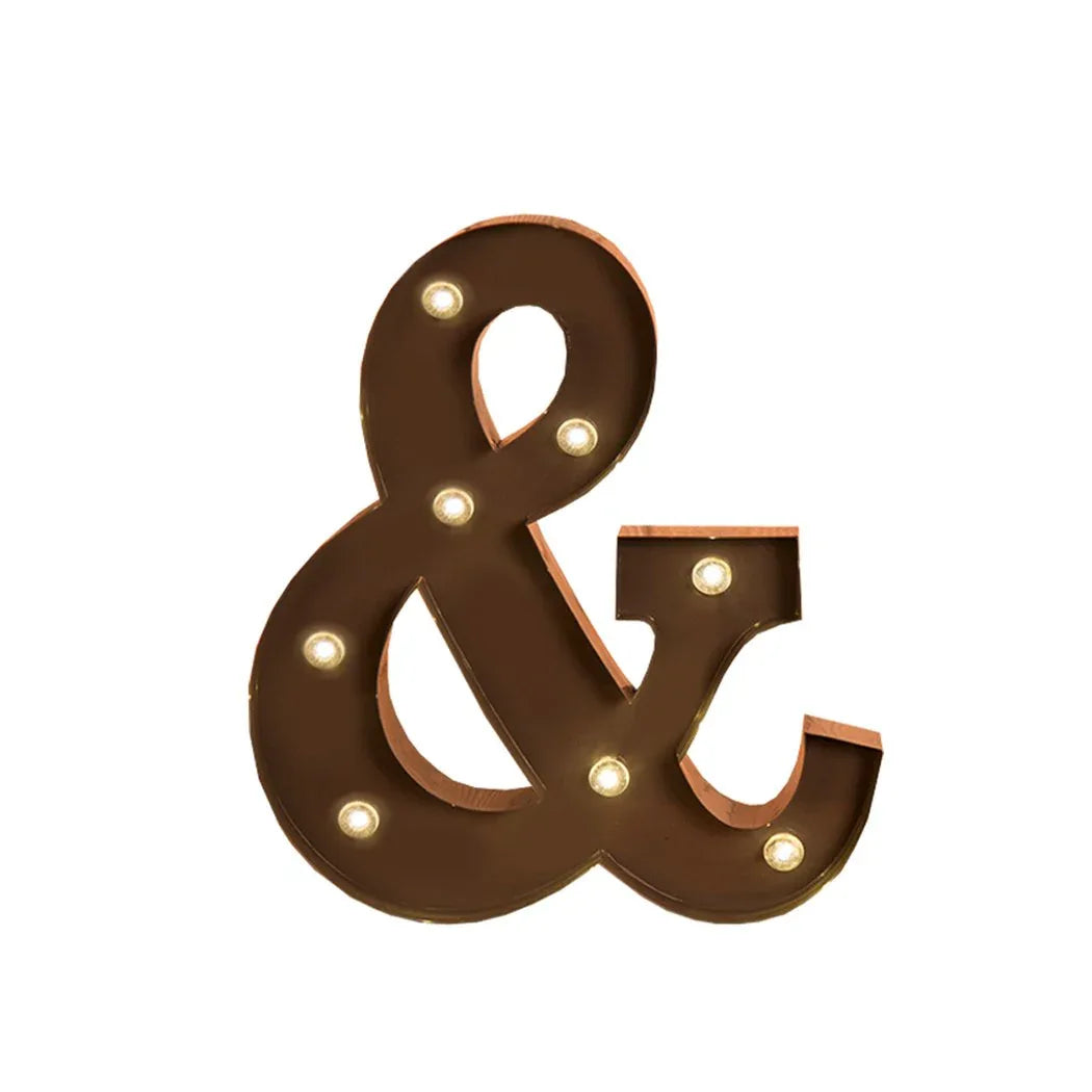 Close-up of illuminated marquee letter lights in metal casing resting on a smooth surface.