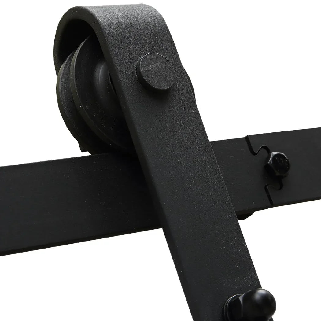 Metal sliding door hardware mounted on a white barn door in a modern home interior.