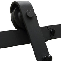 Metal sliding door hardware mounted on a white barn door in a modern home interior.
