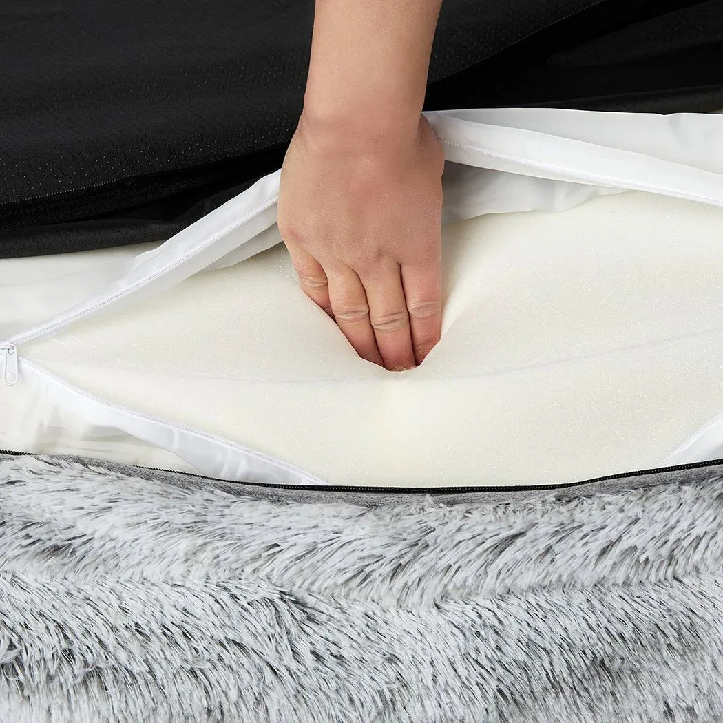 Orthopedic pet bed's plush fabric and supportive bolster highlighted in close-up