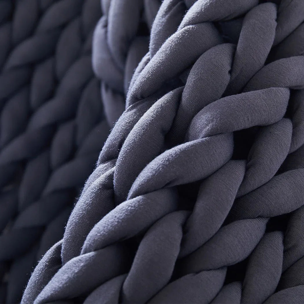 Close-up of chunky knit weighted blanket strands with complex knit pattern and plush feel.