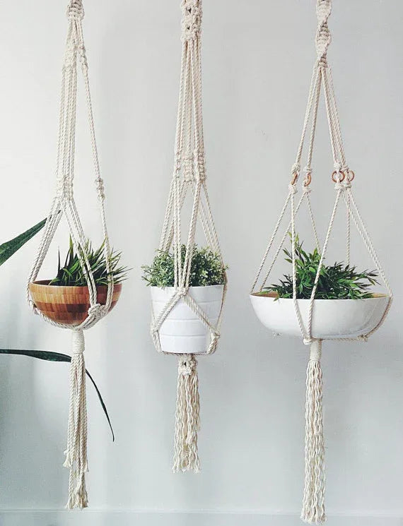 Handcrafted macrame plant hanger made from natural cotton rope hanging indoors.