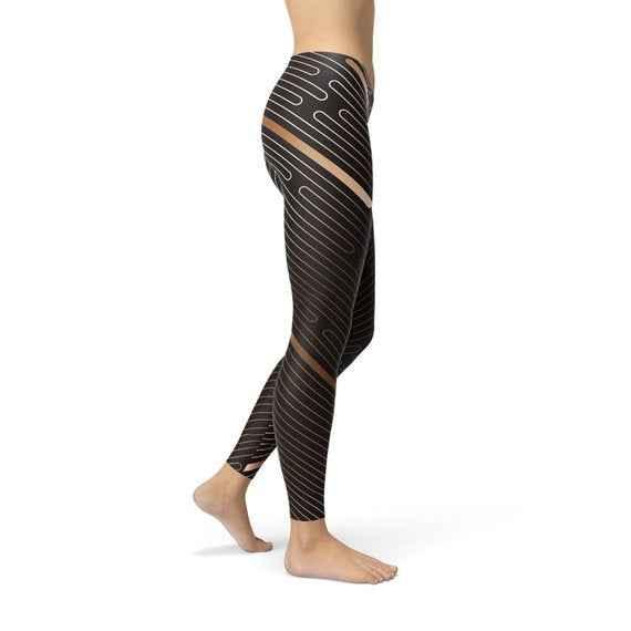 Close-up side view of women's brown leggings featuring white horizontal stripes, showcasing fabric texture