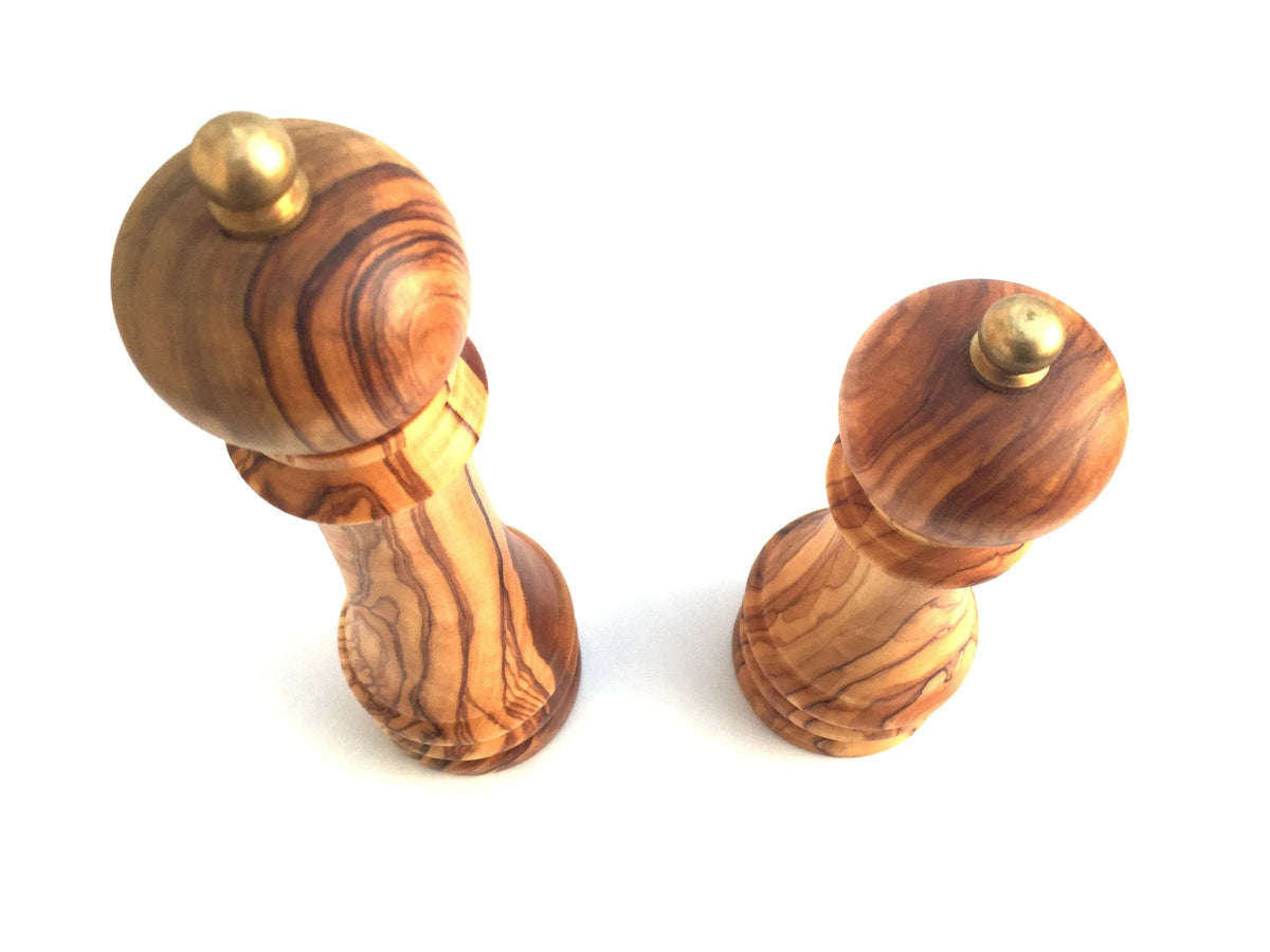 Side view of a smooth wooden pepper mill with a metal turning knob.