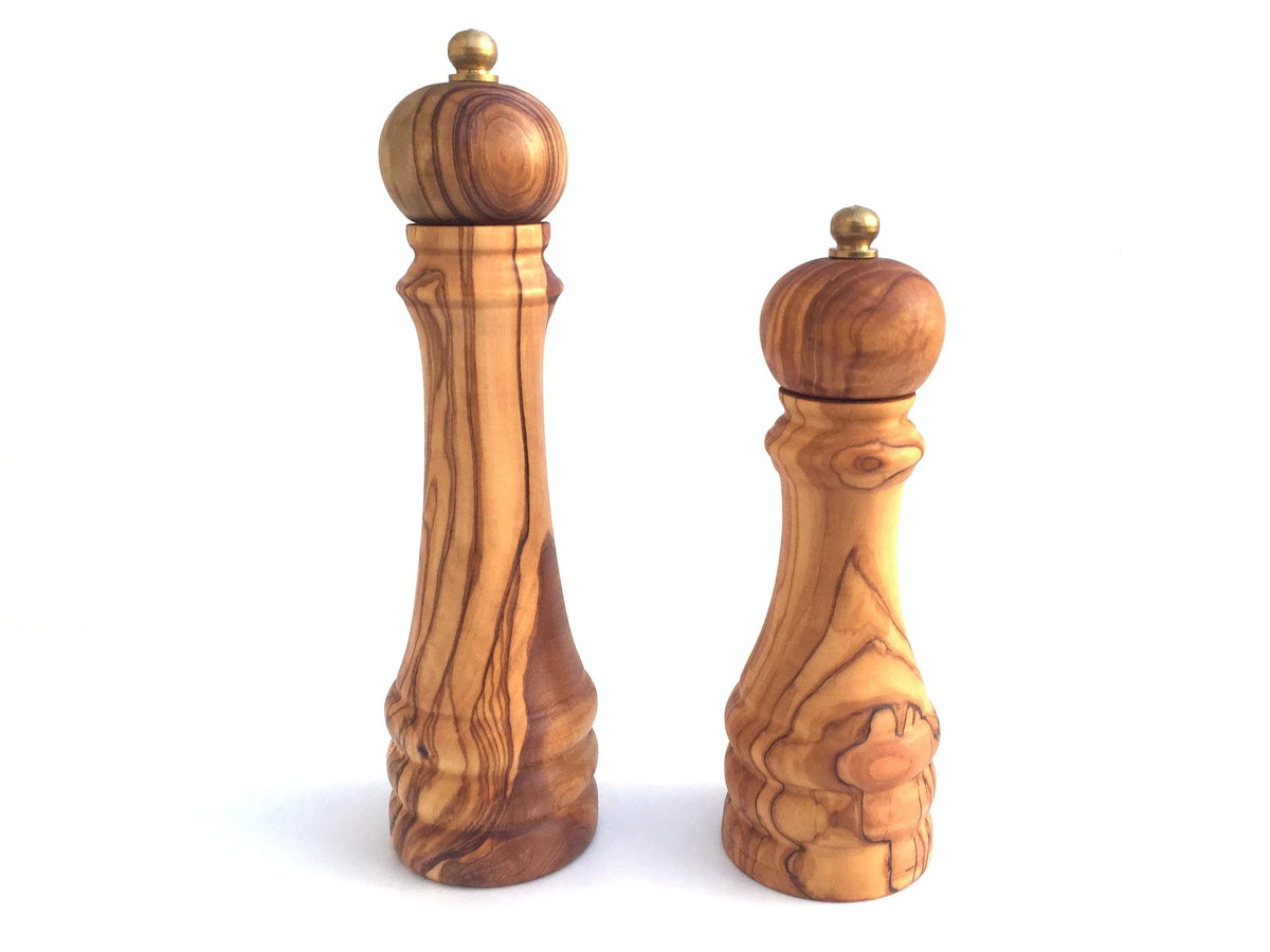 Classic wooden pepper mill with metallic grinder top on a plain background.