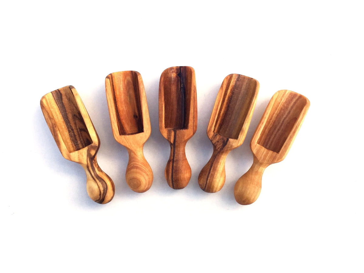 Set of five small 6 cm salt scoops neatly arranged on a white surface.