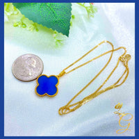 Necklace featuring a blue and gold four-leaf clover pendant on an 18-inch fine gold chain.