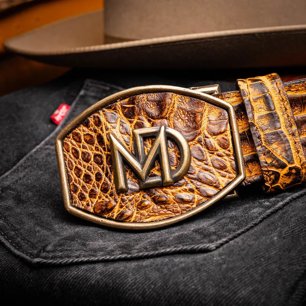 Close-up lifestyle shot of the IOWA mustard brown caiman belt worn with dark pants