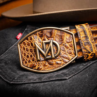 Close-up lifestyle shot of the IOWA mustard brown caiman belt worn with dark pants