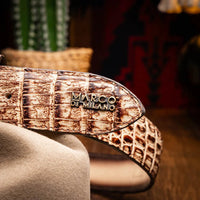 Man wearing Iowa Caiman belt with detailed Western buckle and tan casual pants outdoors.