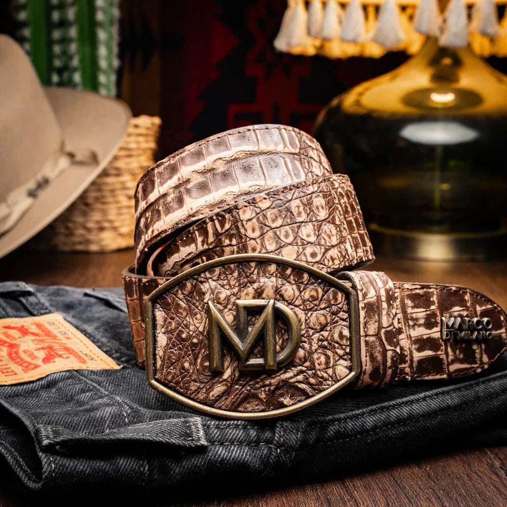Model wearing stone brown Iowa caiman crocodile belt with western design and jeans outdoors.
