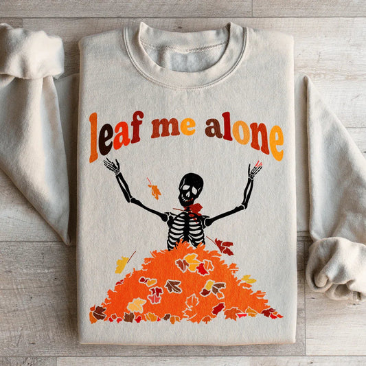 Sand color sweatshirt with a colorful autumn leaf design and Leaf Me Alone Fall text