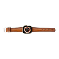 Close-up of tan leather Apple Watch band showing texture and stitching detail.