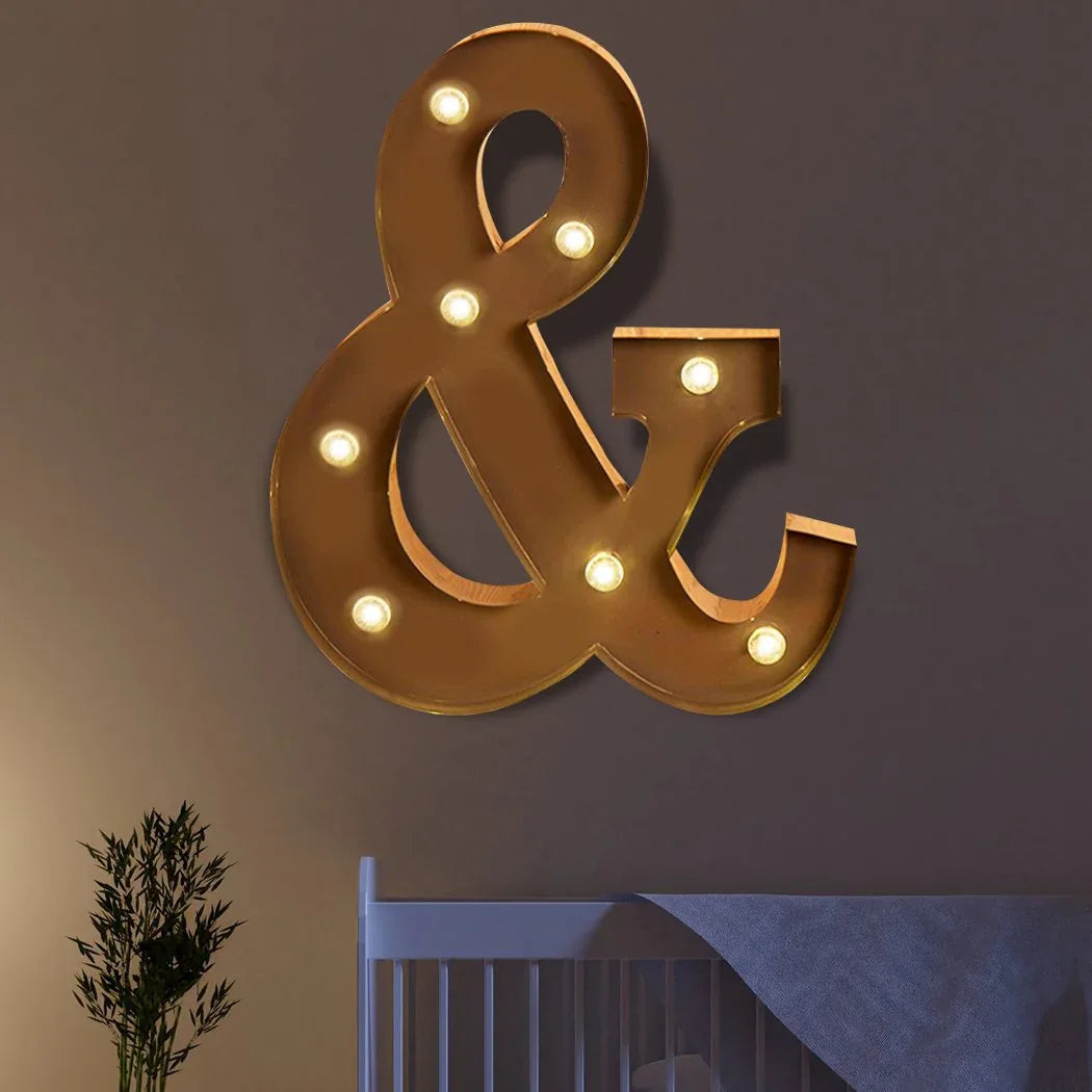 Lifestyle scene featuring LED metal letter lights glowing warmly on a rustic wooden surface.