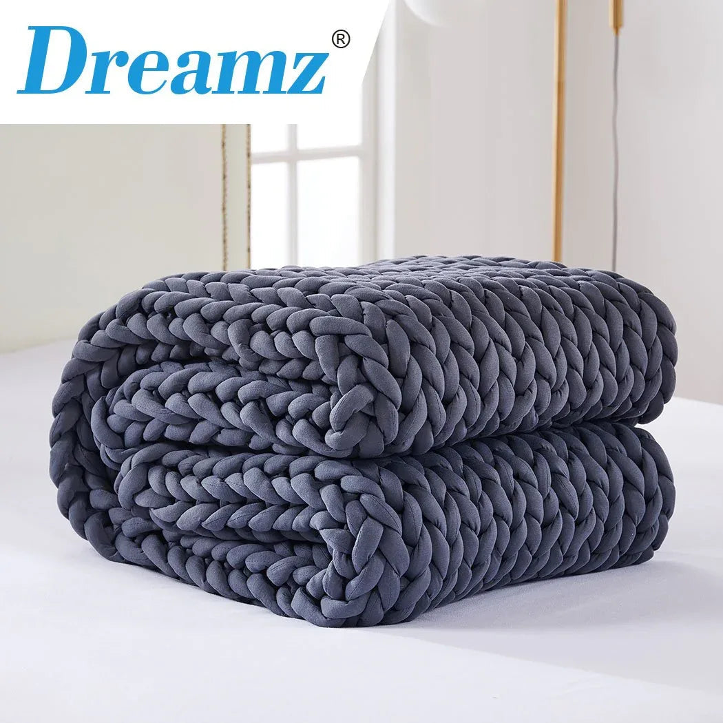 Person relaxing on a couch wrapped in the chunky bulky knit weighted blanket.