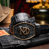 Man wearing Marlboro black caiman skin belt with jeans outdoors in casual lifestyle setting.