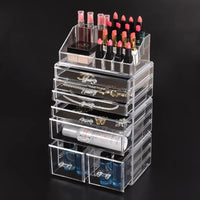 Close-up of clear acrylic drawers containing makeup and jewelry items