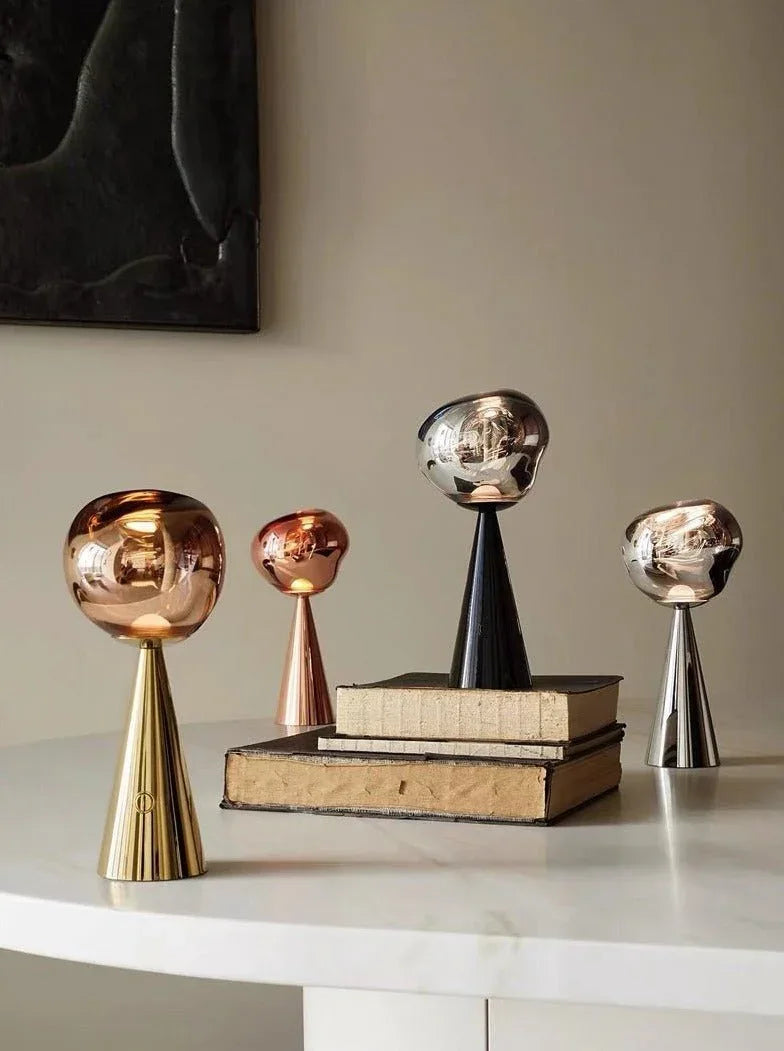 Modern Nordic bedside table lamp with a warm, glowing dimmable LED light in a molten glass inspired shape.