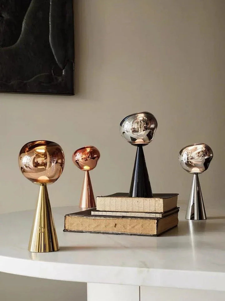 Modern Nordic bedside table lamp with a warm, glowing dimmable LED light in a molten glass inspired shape.