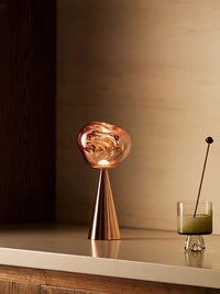 Dimmed LED table lamp casting a soothing warm light beside a bed in a minimalist room.