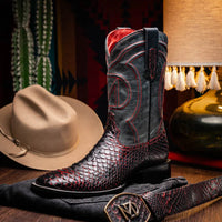 Person wearing Missouri BlackCherry cowboy boots outdoors on wooden decking.