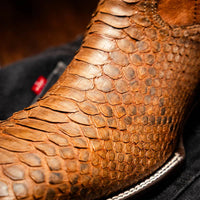 Close-up of Missouri boot worn outdoors showcasing python skin texture and square toe.