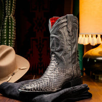 Lifestyle image of white python skin Missouri cowboy boots outdoors with jeans and a casual stance.