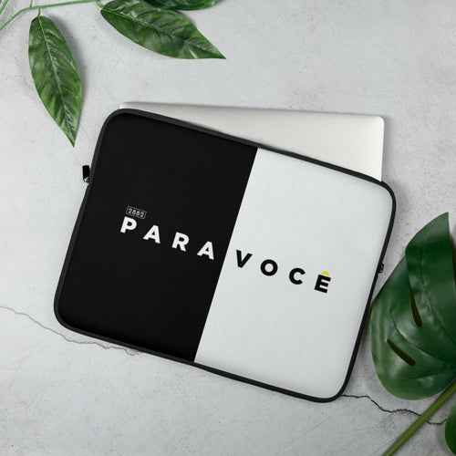 A modern laptop sleeve featuring a bold black and white color block design, shown zipped closed on a desk.