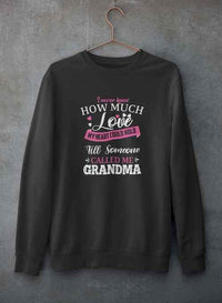 Gray crewneck sweatshirt featuring a loving quote, showcased hanging on a textured concrete wall.
