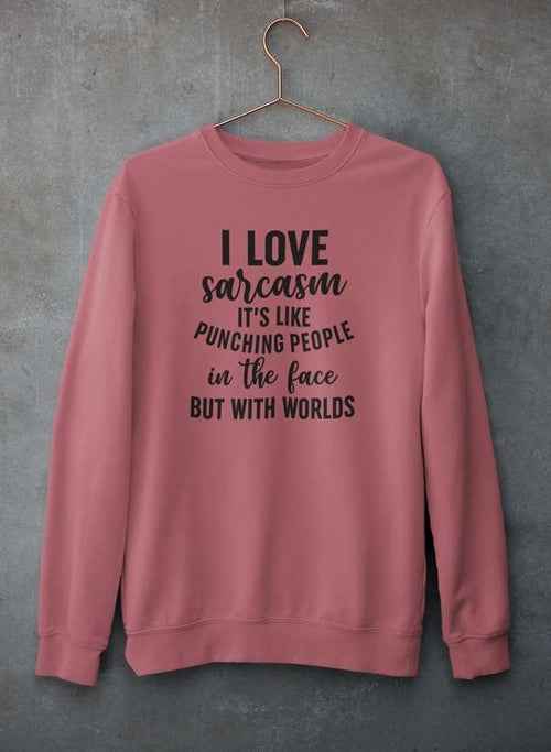 Gray sweatshirt featuring 'I Love Sarcasm' text, hanging against a textured concrete wall.