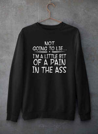 Light gray crewneck sweatshirt with bold black text 'Not Going To Lie... Im A Little Bit Of A Pain In The Ass' hanging on