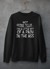 Close-up of light gray crewneck sweatshirt with text print hanging against rough concrete wall.