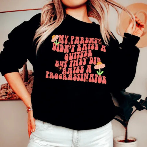 Black sweatshirt displayed flat showing front with the phrase 'My Parents Didn't Raise A Quitter' in bold white text.