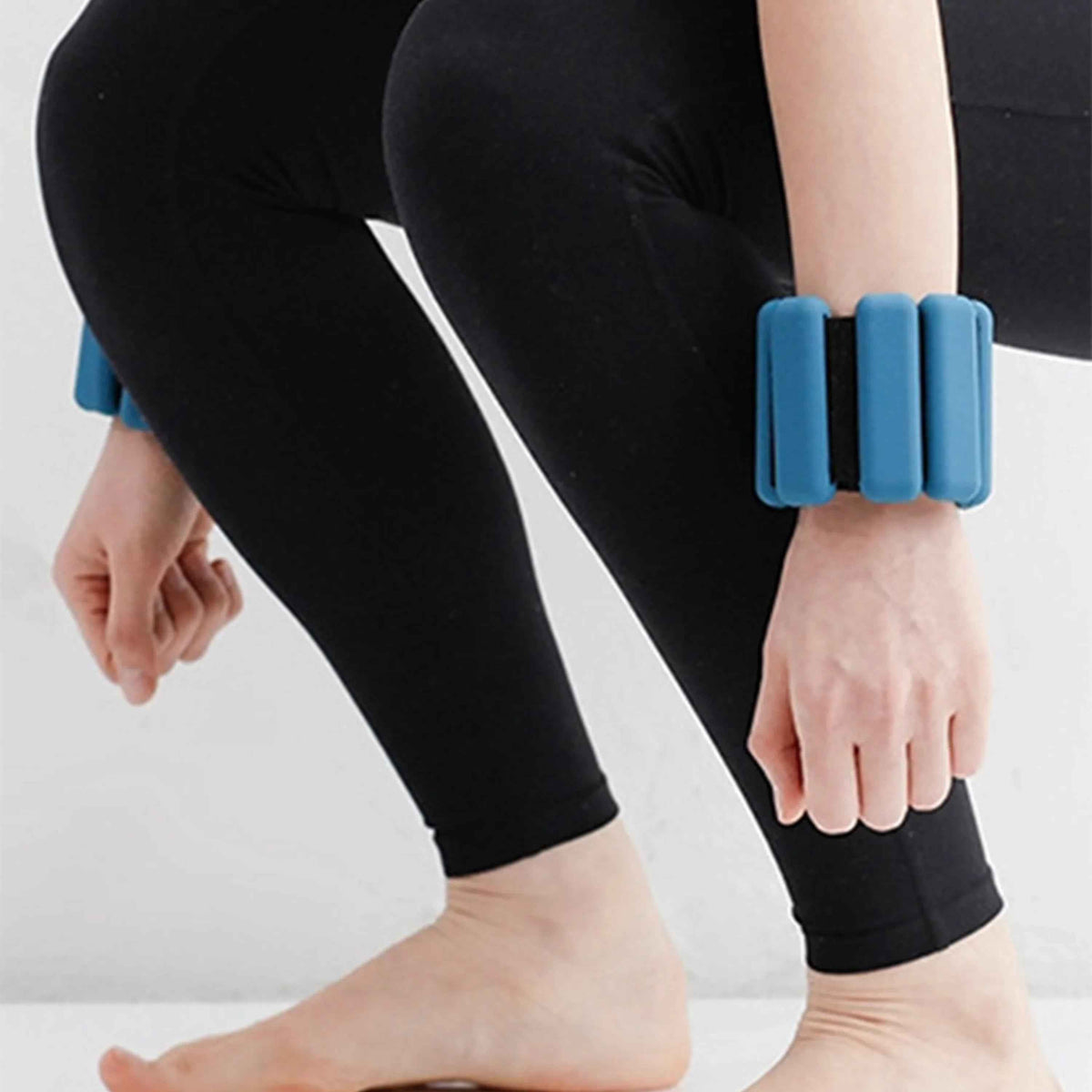 Pair of adjustable silicone-coated wrist or ankle weights with Velcro straps, each weighing 1 pound, on a white.