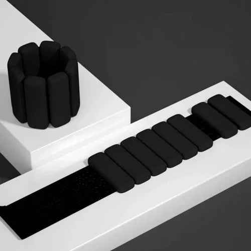 Pair of grey silicone-coated 1 lb wrist or ankle weights with adjustable Velcro straps, shown on a white background.