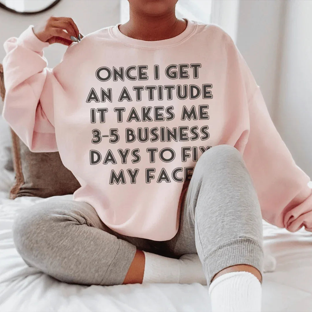 Peach colored sweatshirt with white text reading 'Once I Get An Attitude' on front.