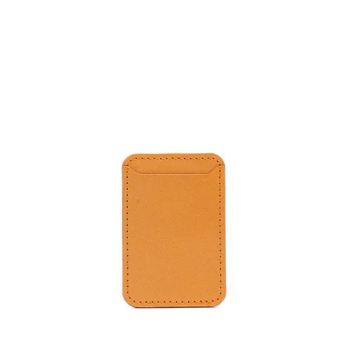 Orange leather MagSafe wallet angled to show stitching and texture on white surface.