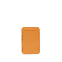 Orange leather MagSafe wallet angled to show stitching and texture on white surface.