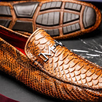Lifestyle image of Pia Cognac python leather loafer paired with rolled-up pants.