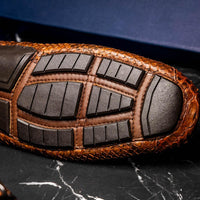 Man walking wearing Pia Cognac python driver shoes in an urban setting.
