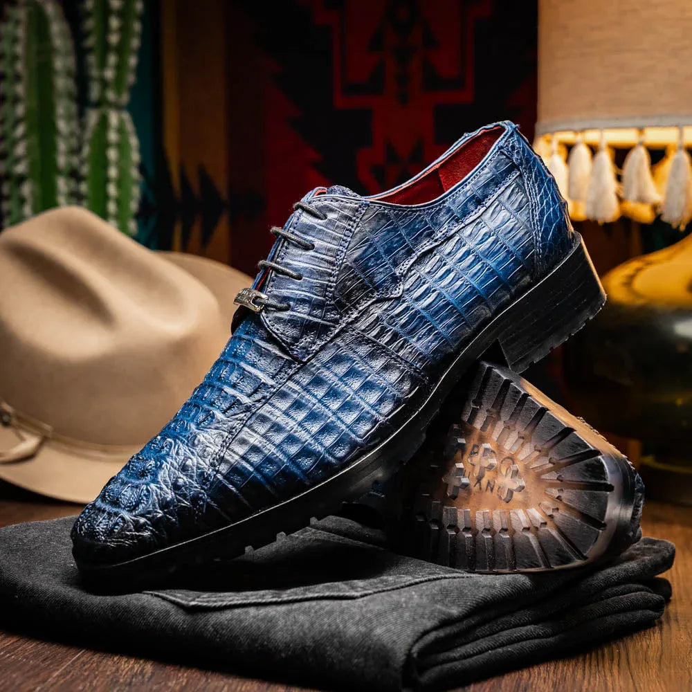 Side view of Ragusa navy blue caiman skin derby shoe paired with navy socks and cuffed pants.
