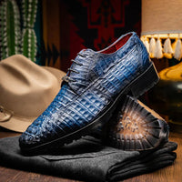 Side view of Ragusa navy blue caiman skin derby shoe paired with navy socks and cuffed pants.